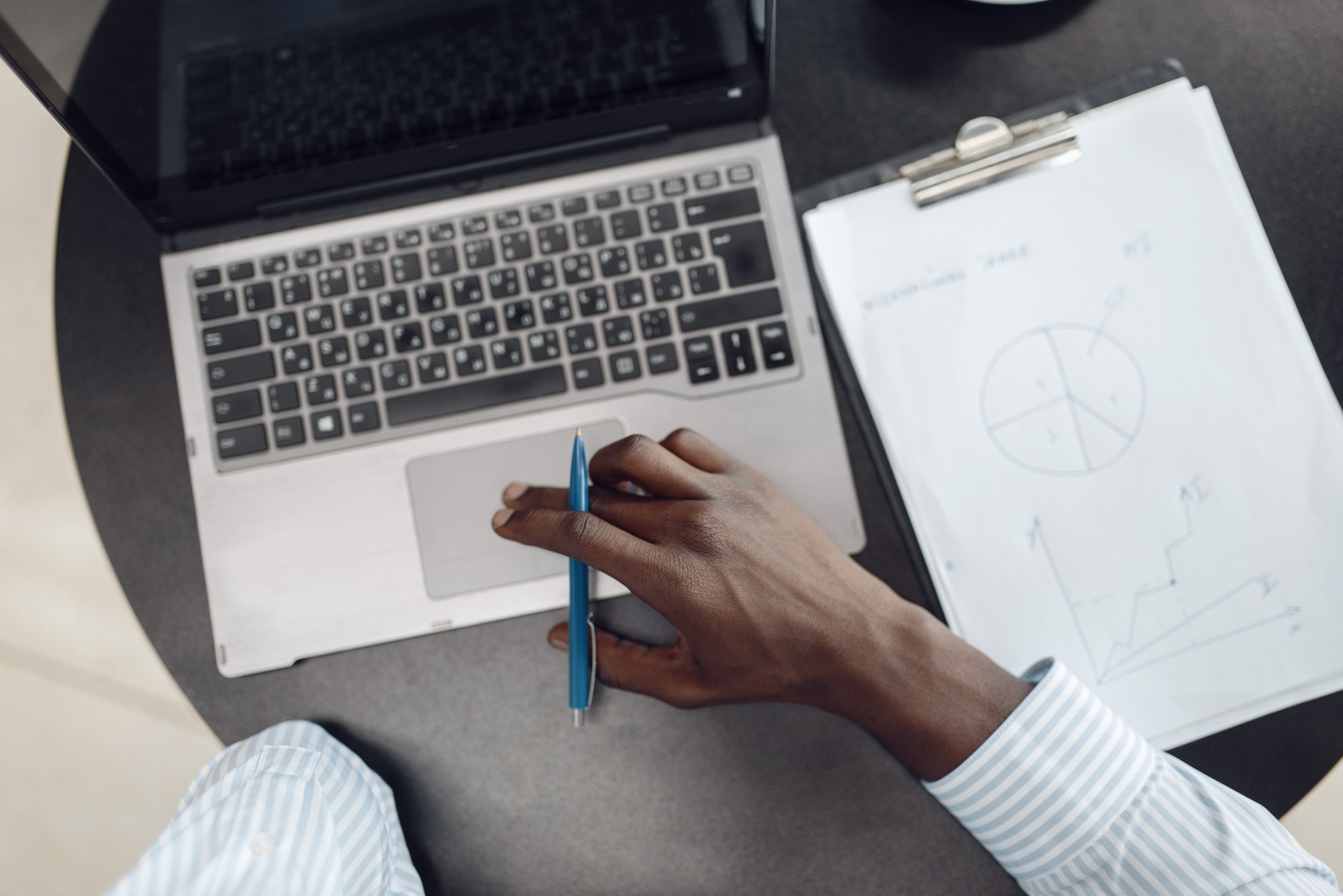 Black businessman working on laptop, top view